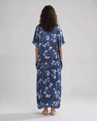 Mujer de espaldas con caftan de seda natural marino largo hasta los tobillos