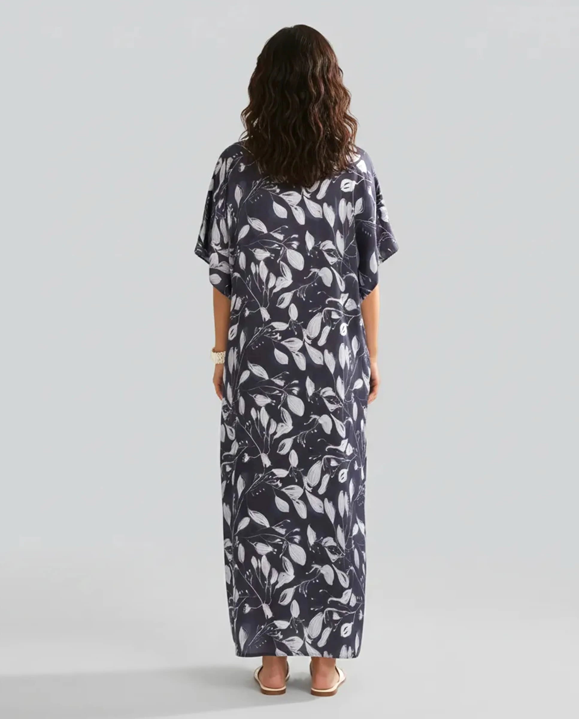 Mujer de espaldas con kaftan marino largo hasta los tobillos color marino con flores