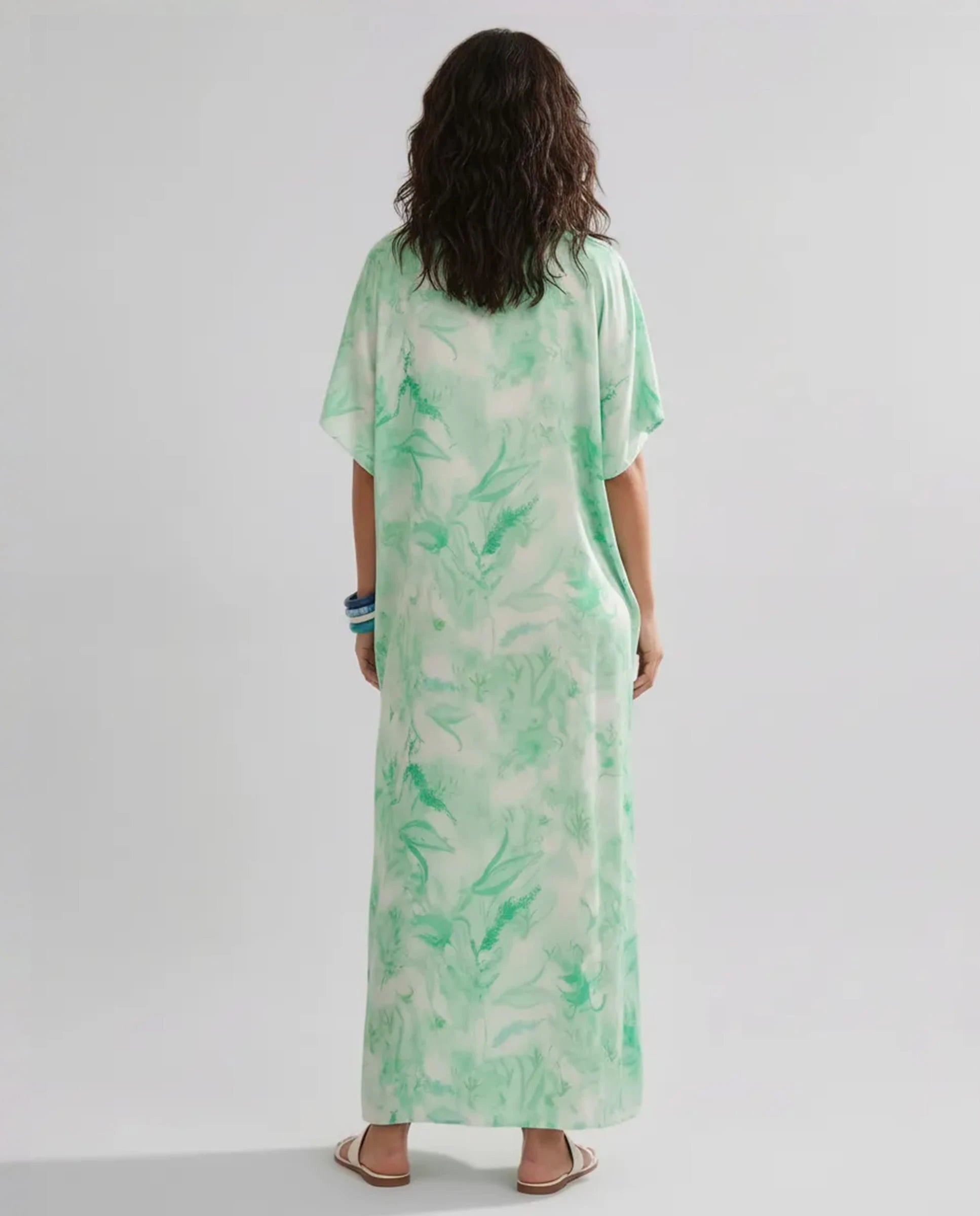 Modelo de espaldas con kaftan de seda verde hasta los tobillos