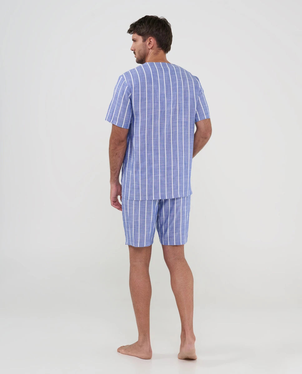 Hombre de espaldas con pijama fresco estilo camisero azul de rayas para verano