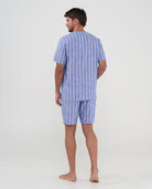 Hombre de espaldas con pijama fresco estilo camisero azul de rayas para verano