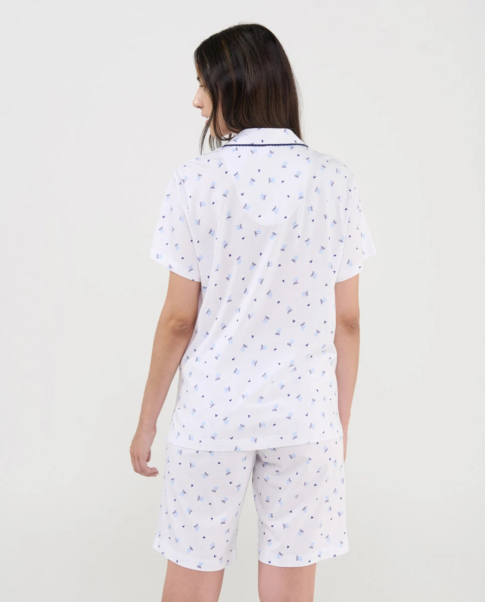 Vista de espaldas de mujer con pijama de verano corto blanco estampado cerecitas marino