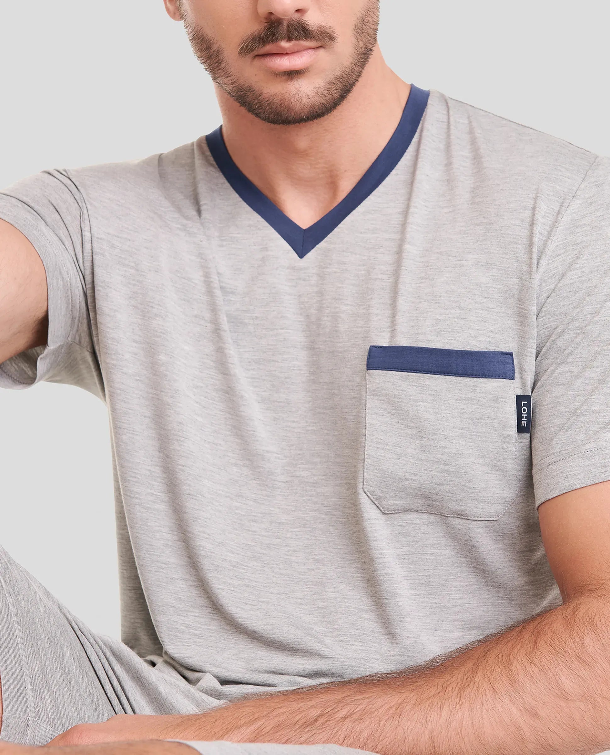 Hombre lleva camiseta de pijama corta de verano a rayas y pantalones cortos azules.