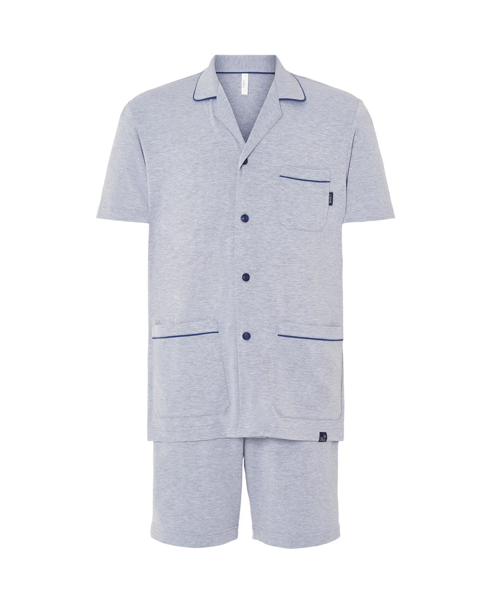 hombre posa con pijama corto veraniego de color azul con pantalón corto de tortuguitas y bolsillos