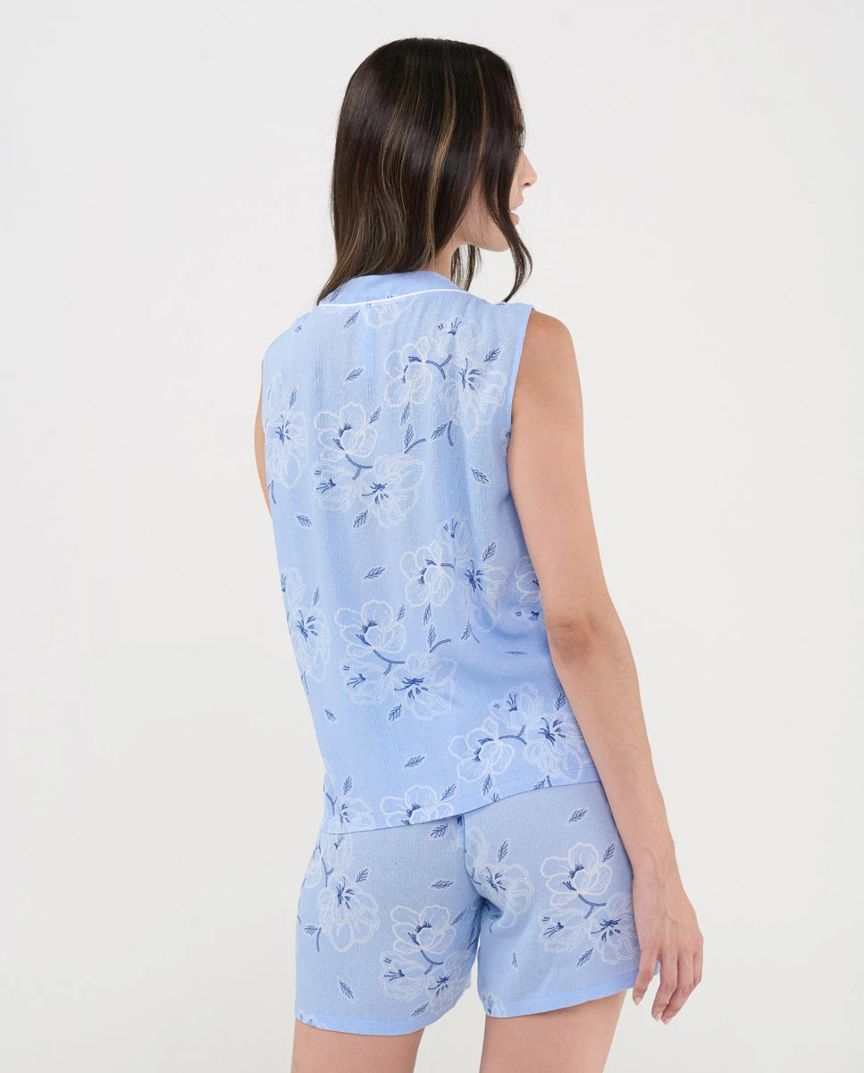 Vista trasera de mujer vistiendo pijama veraniego celeste con estampado de flores, corto y sin mangas