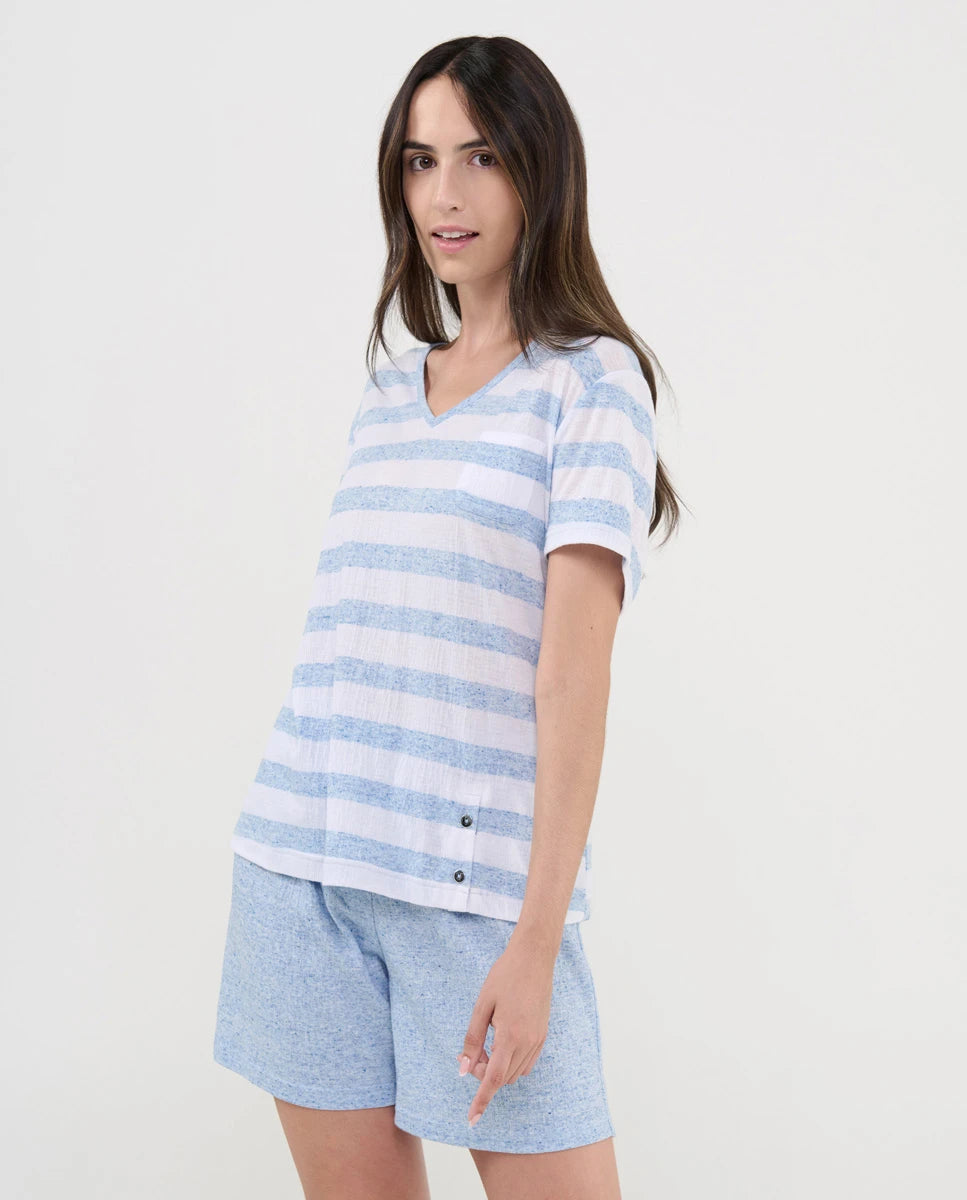 Mujer viste pijama corto de verano con camiseta de rayas celeste y cuello pico y pantalón liso a juego