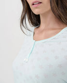 Detalle de cuello pico con botones y lacito, diseño desagujado de estrellitas