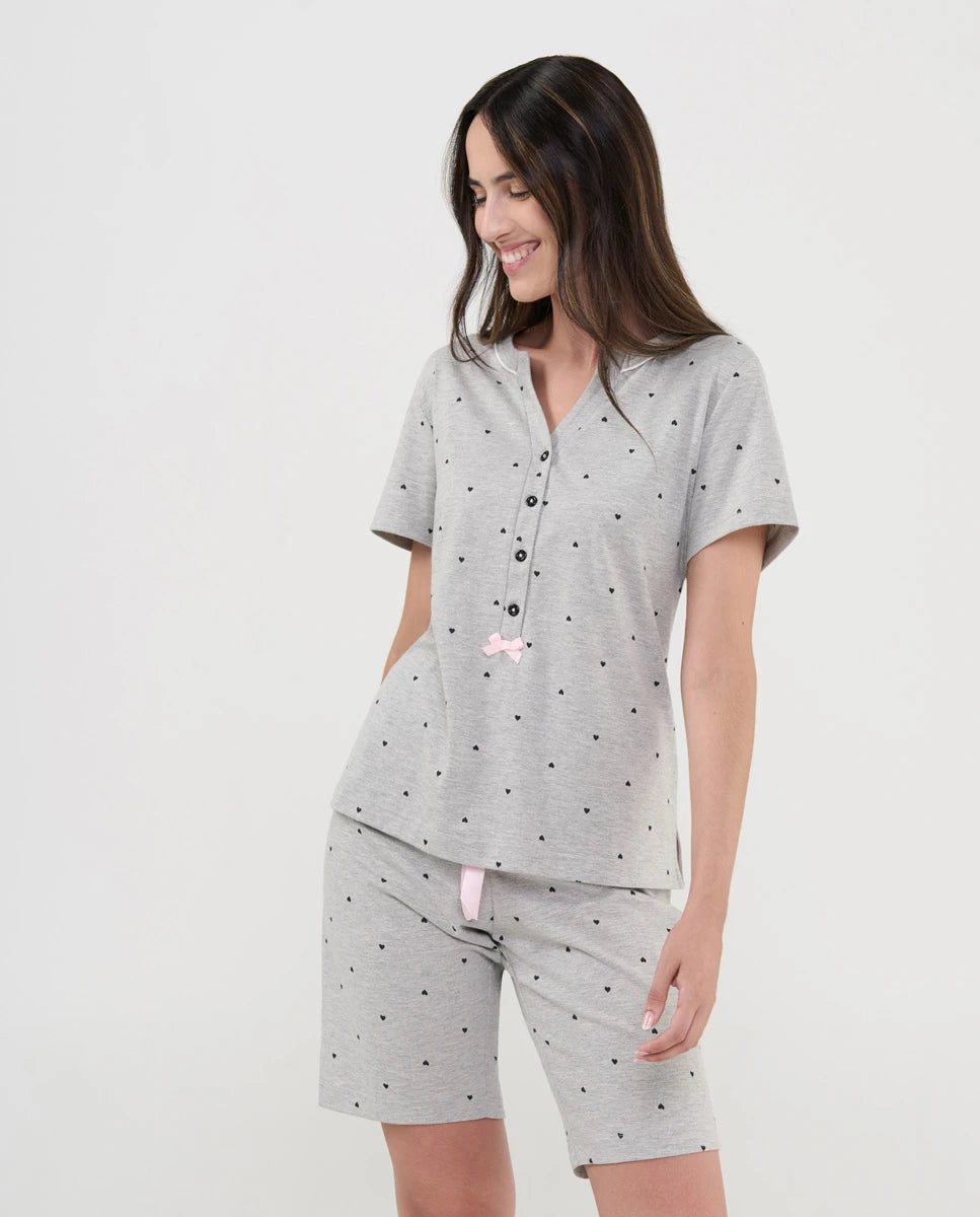 Mujer con pijama corto gris vigoré de manga corta, cuello abierto abotonado y estampado de corazones