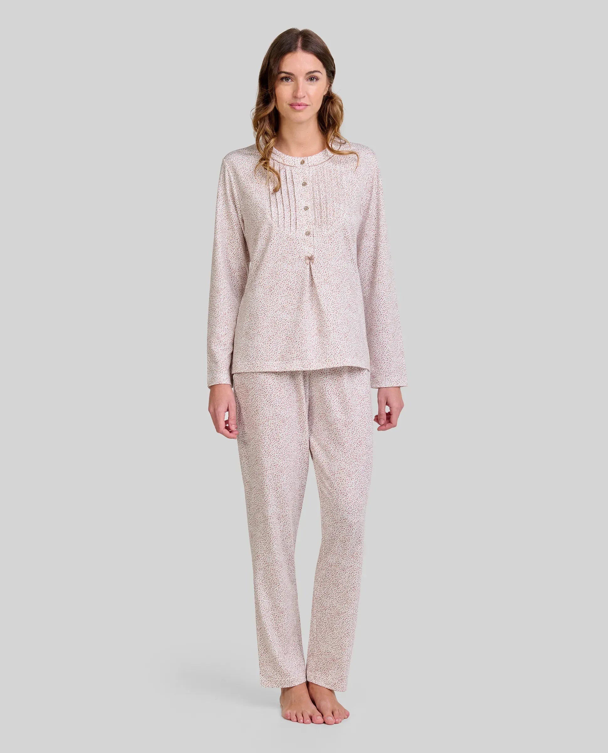 Mujer posando con sutil y elegante pijama de manga larga y pantalón de estampado floral camel.
