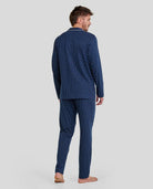 Hombre de espaldas con pijama largo de invierno azul marino