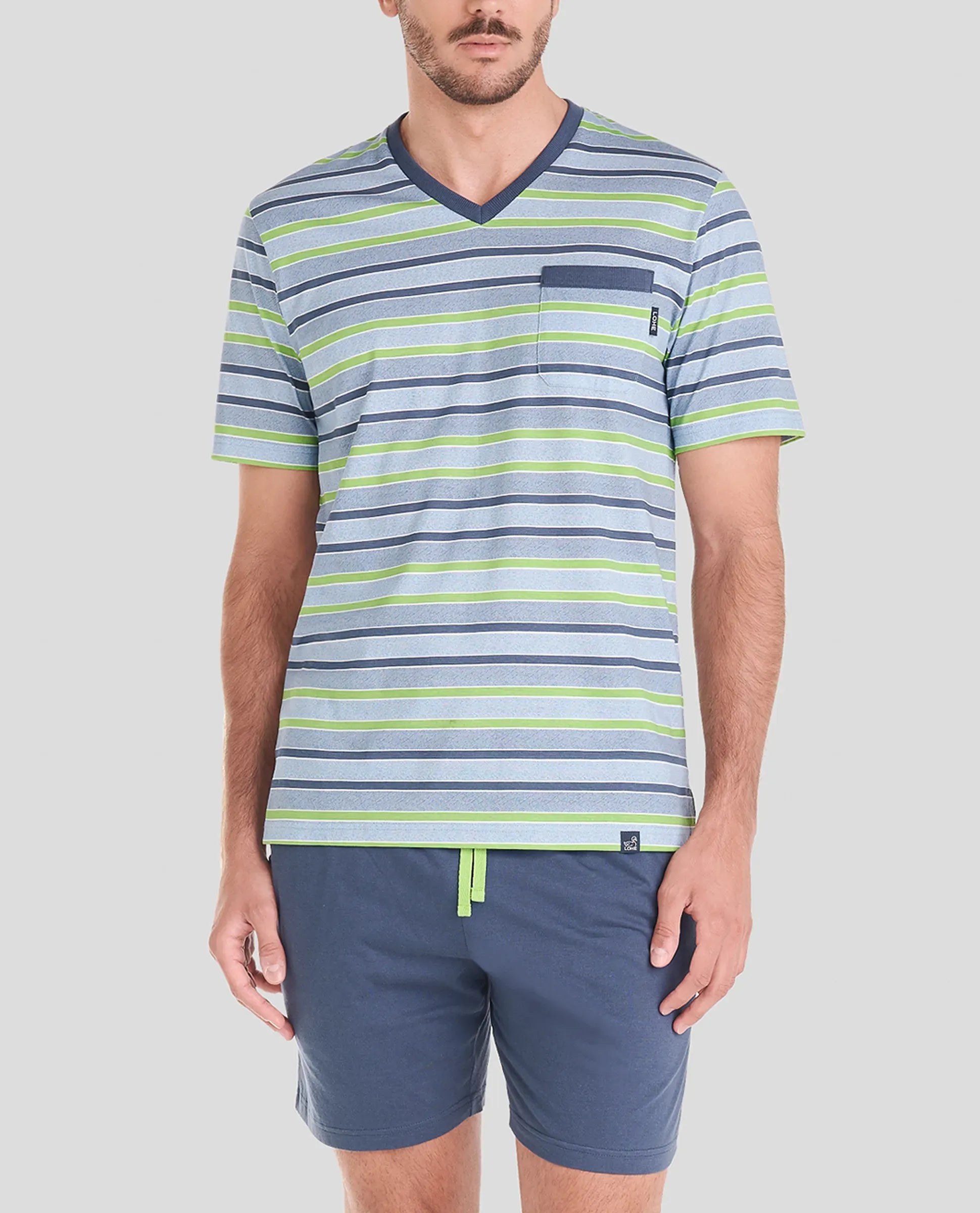 Hombre lleva camiseta de pijama corta de verano a rayas y pantalones cortos azules.