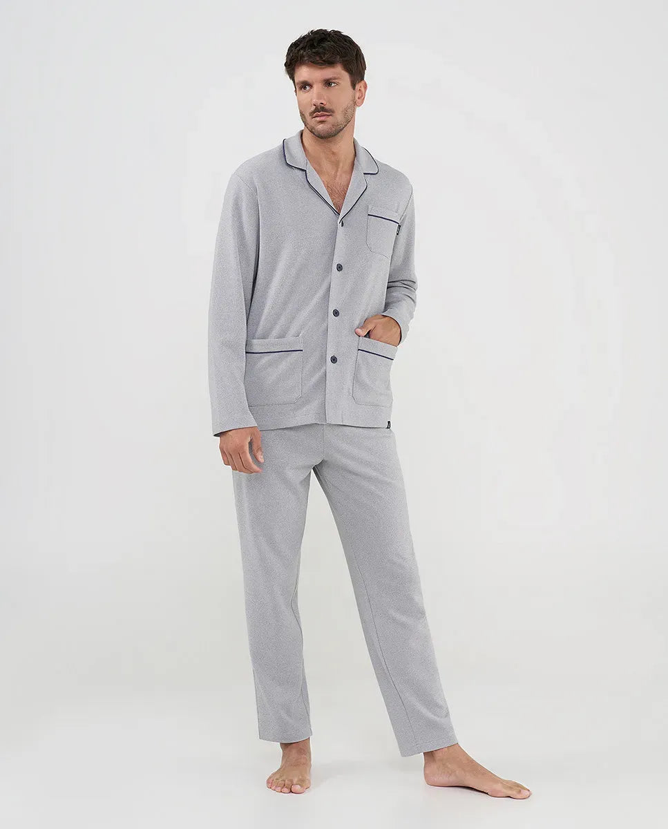 Hombre con pijama gris claro de manga larga, ribetes vivo negros y botones frontales, ideal para dormir.