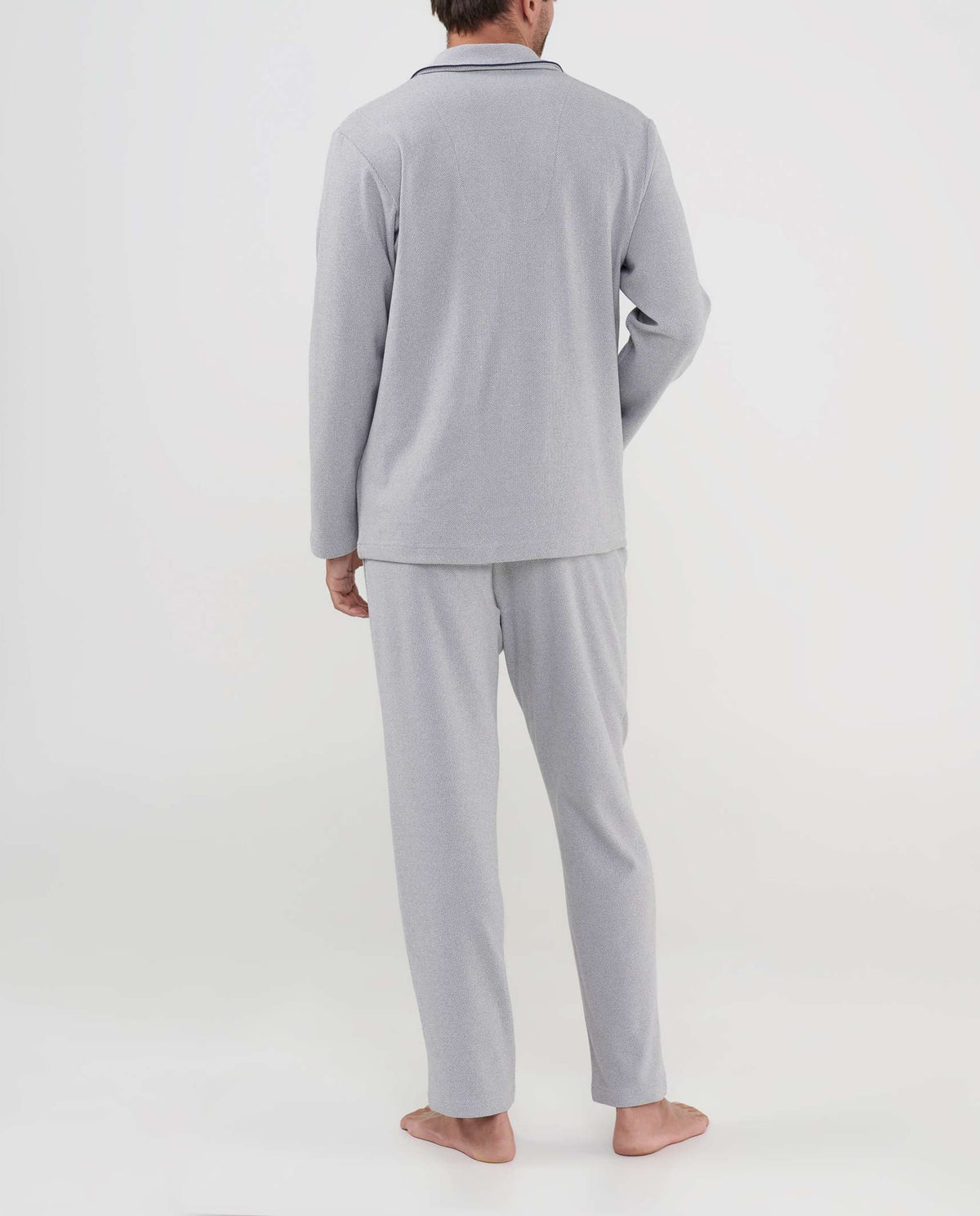 Hombre de espaldas luce un pijama gris claro de manga larga y pantalón para invierno