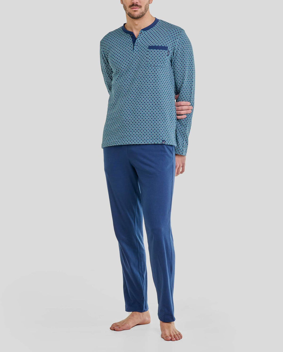 Hombre con pijama azul de manga larga de estampado geométrico, cuello abierto botones y pantalón largo