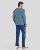 Hombre de espaldas con pijama de invierno de estampado geométrico en tonos azules