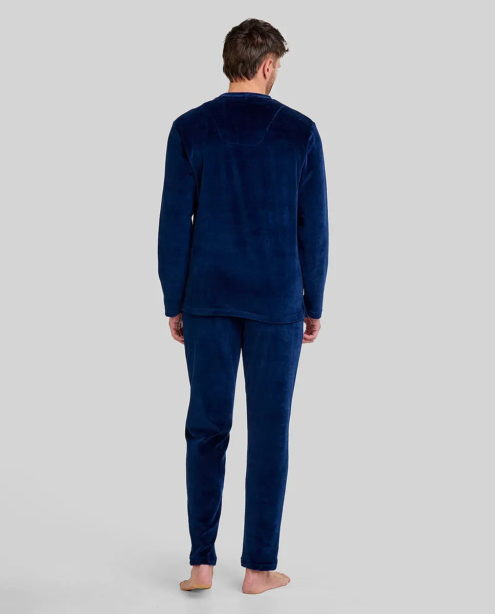 hombre de espaldas con confortable pijama largo de terciopelo liso marino con bolsillos laterales