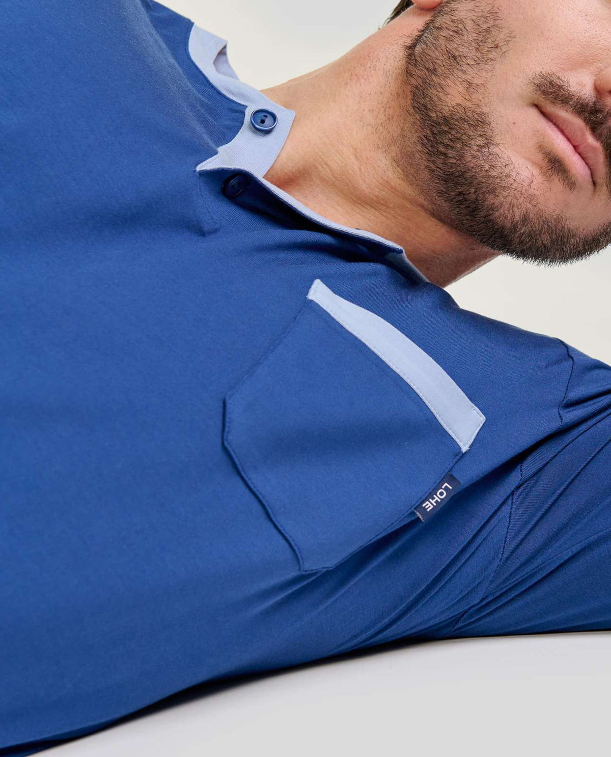 Detalle de cuello abierto con botones del pijama de modal marino para hombre