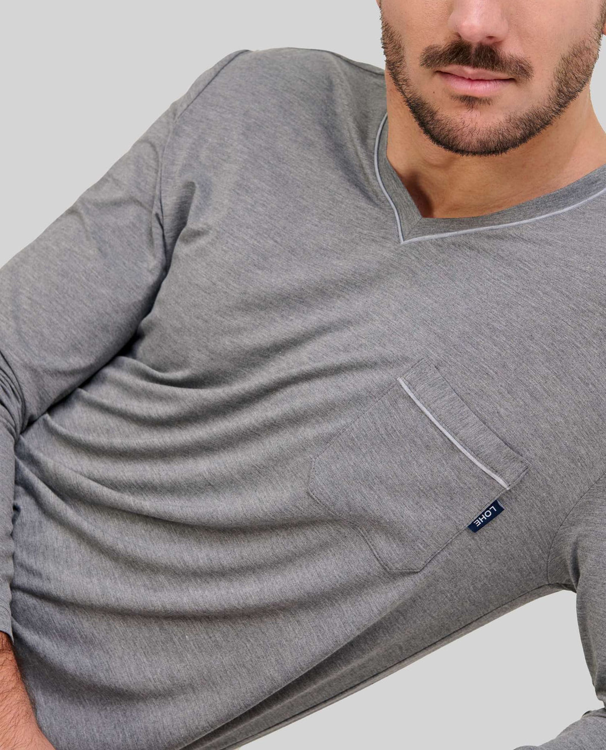 Detalle de cuello abierto con botones del pijama de modal gris para hombre