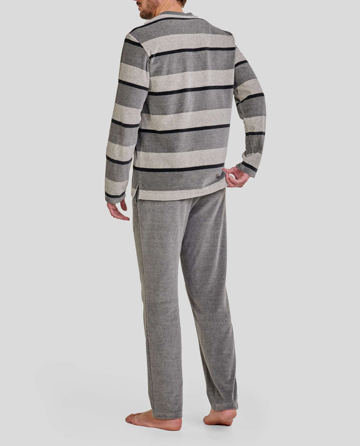 Hombre de espaldas con pijama largo de invierno gris de terciopelo