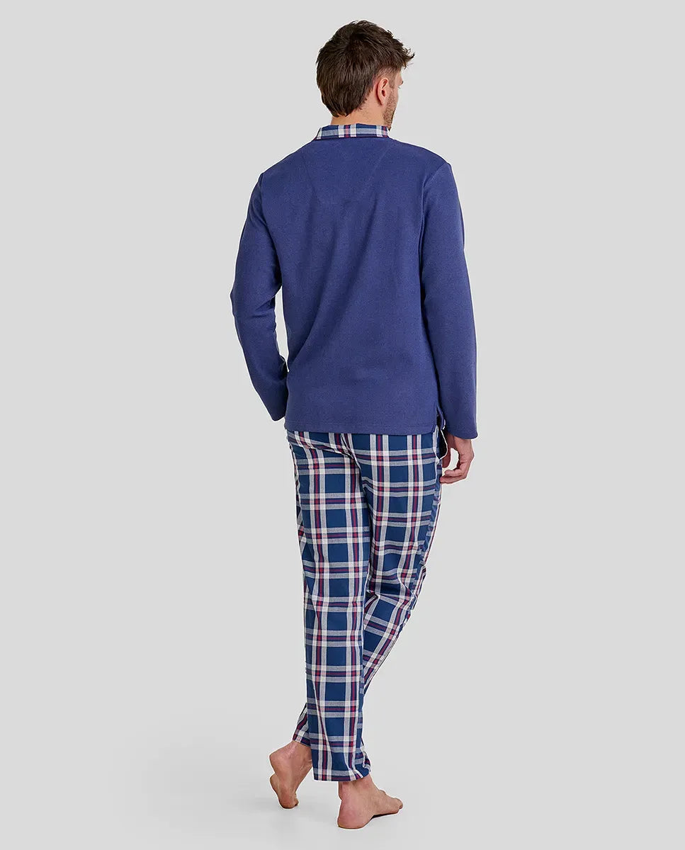 Hombre posa de espaldas con pijama largo de invierno con top azul y pantalón de cuadros con bolsillos a conjunto