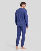 Hombre de espaldas con cómodo pijama largo de invierno azul marino