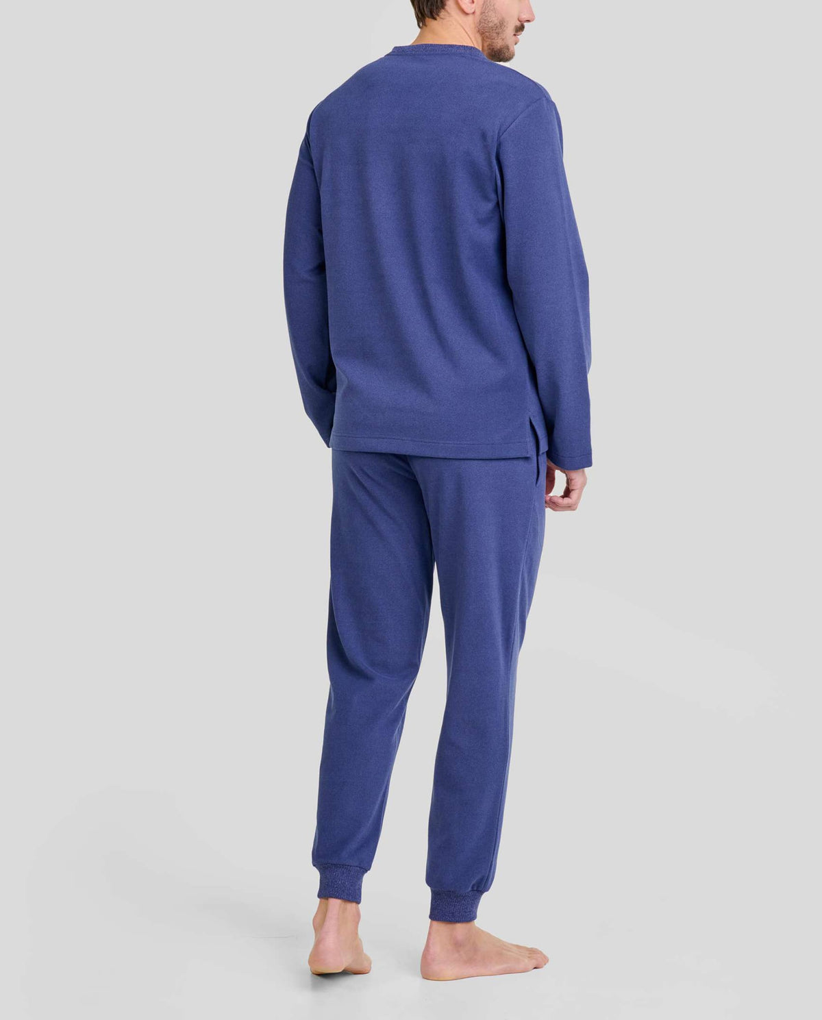 Hombre de espaldas con cómodo pijama largo de invierno azul marino
