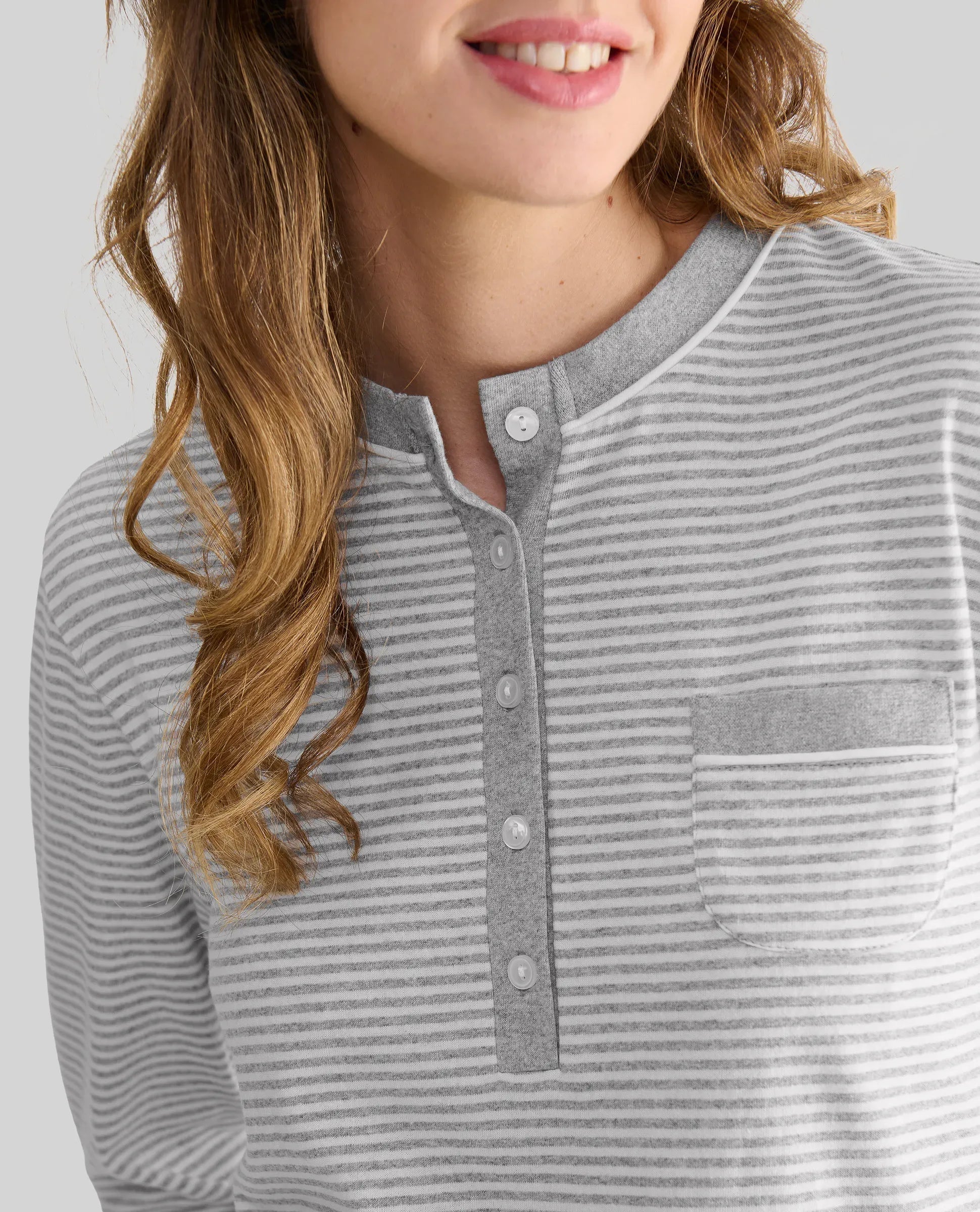Detalle del escote con pata abotonada del top de pijama de invierno gris a rayas y bolsillo decorativo