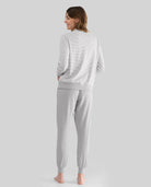 Mujer de espaldas con pijama de invierno gris con top a rayas y puños elásticos