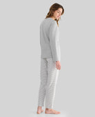 Mujer de perfil con pijama de invierno gris y pantalón de rayas a juego