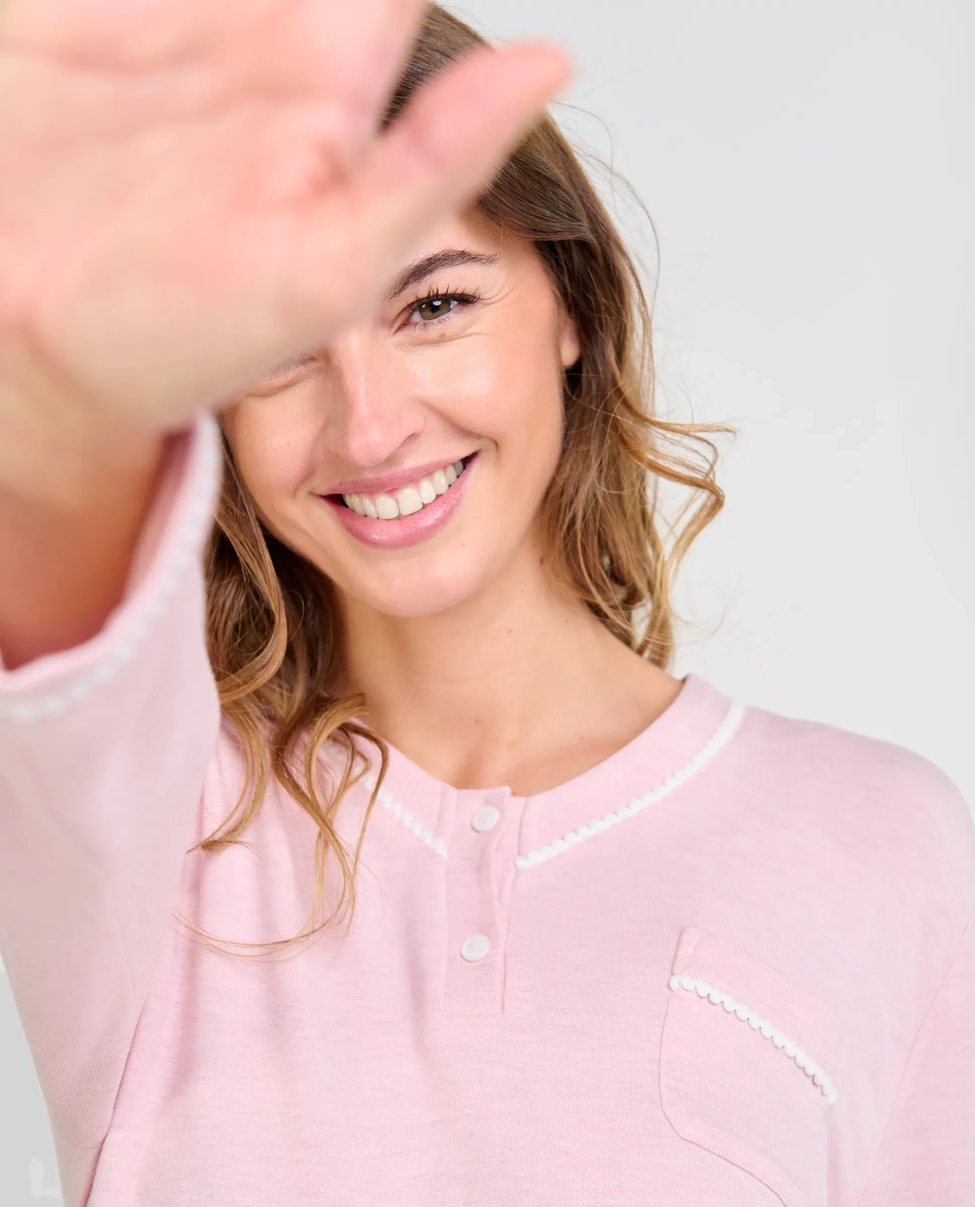 Detalle de pijama de invierno para mujer melange rosa suave con cuello pico abotonado