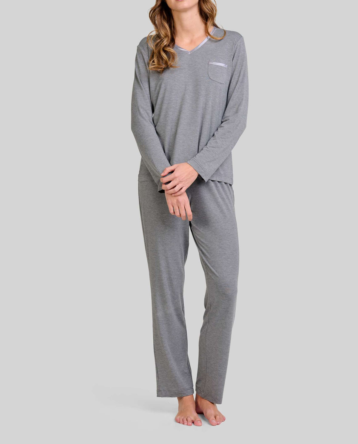 Mujer con pijama largo en tejido modal gris con escote pico y detalles en raso