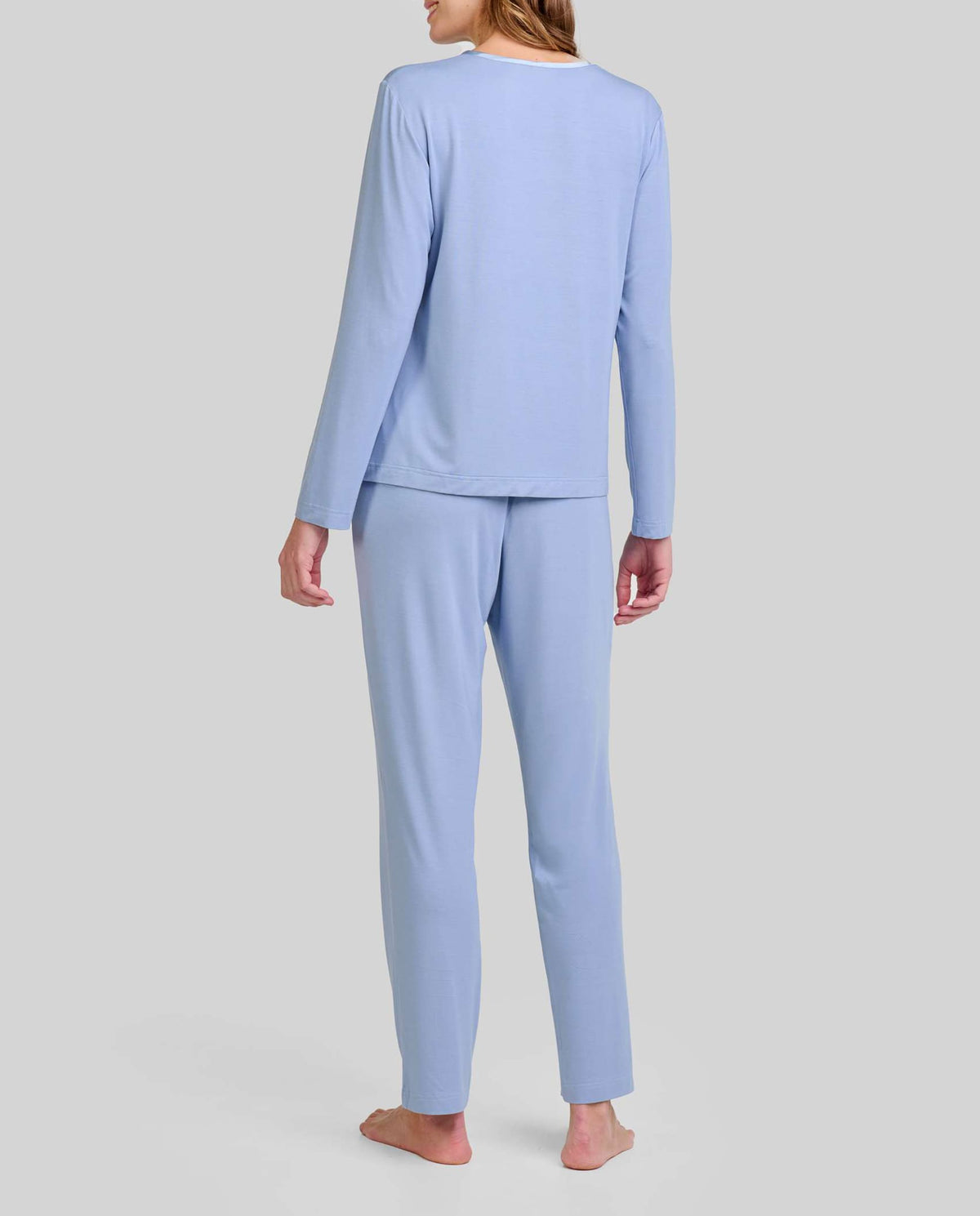 Mujer de espaldas con elegante pijama modal azul acero de manga larga