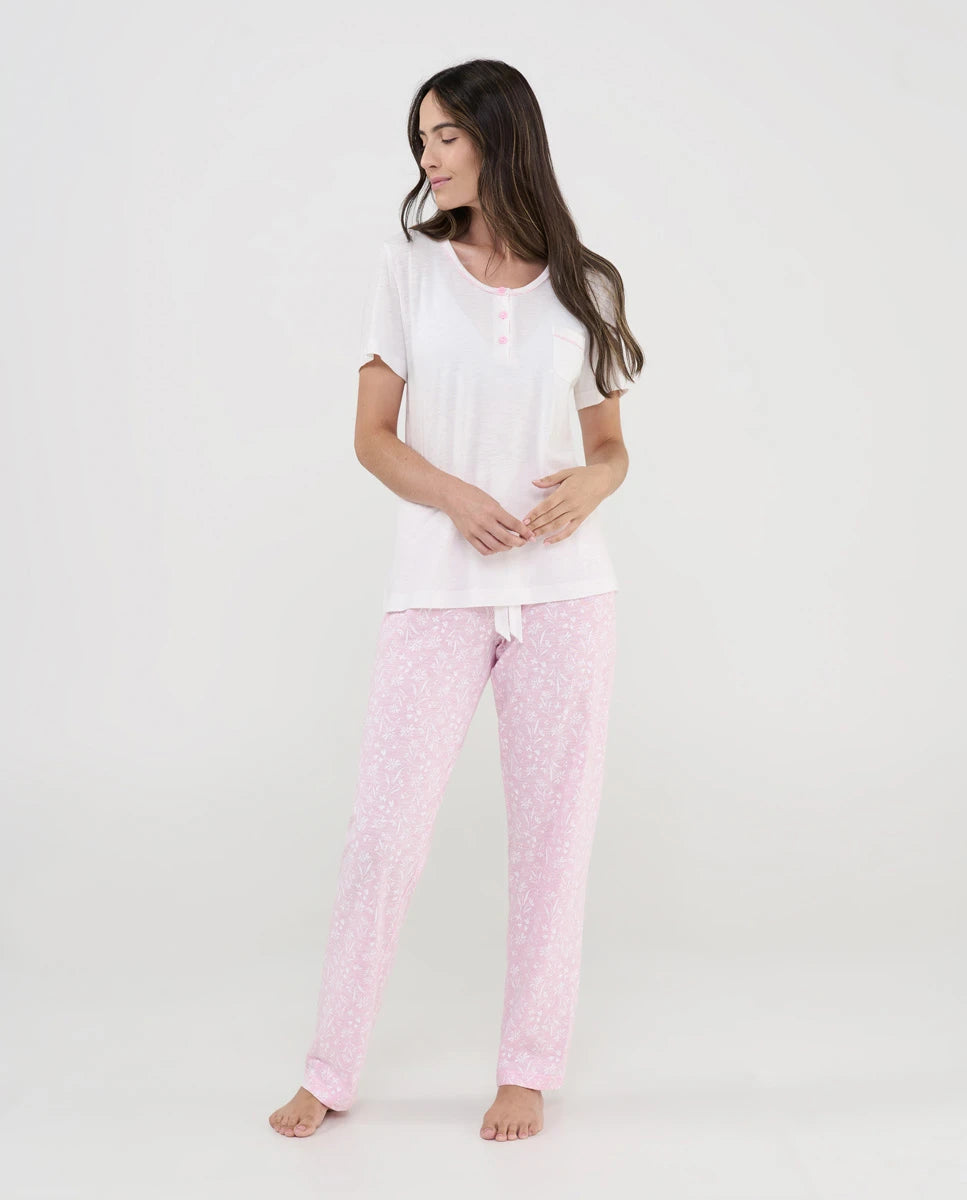 Mujer viste pijama de verano de manga corta en punto blanco y pantalón largo rosa con florecitas