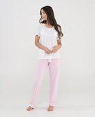 Mujer viste pijama de verano de manga corta en punto blanco y pantalón largo rosa con florecitas