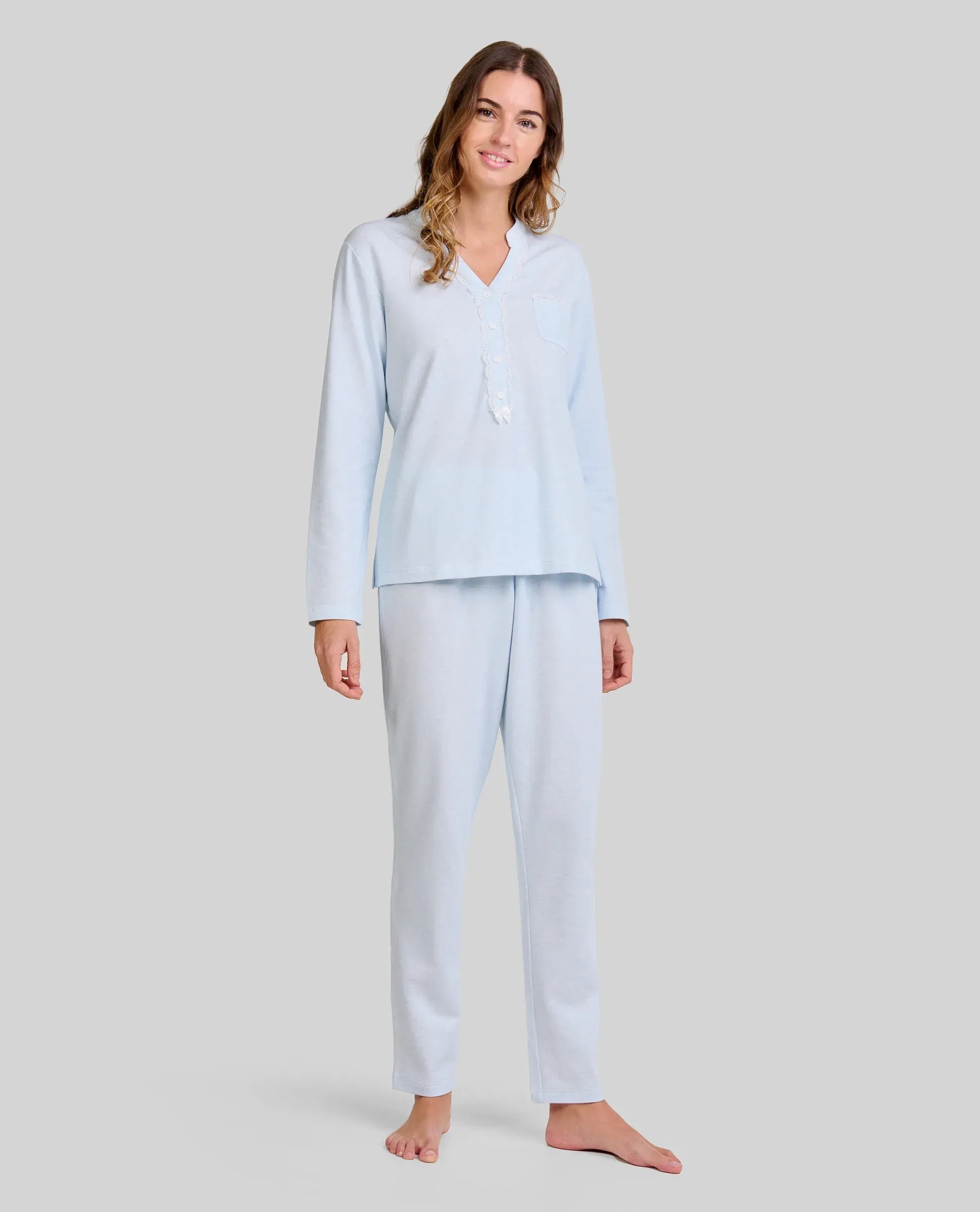 Mujer con pijama largo lencero color celeste de cuello abierto con puntilla y lazo