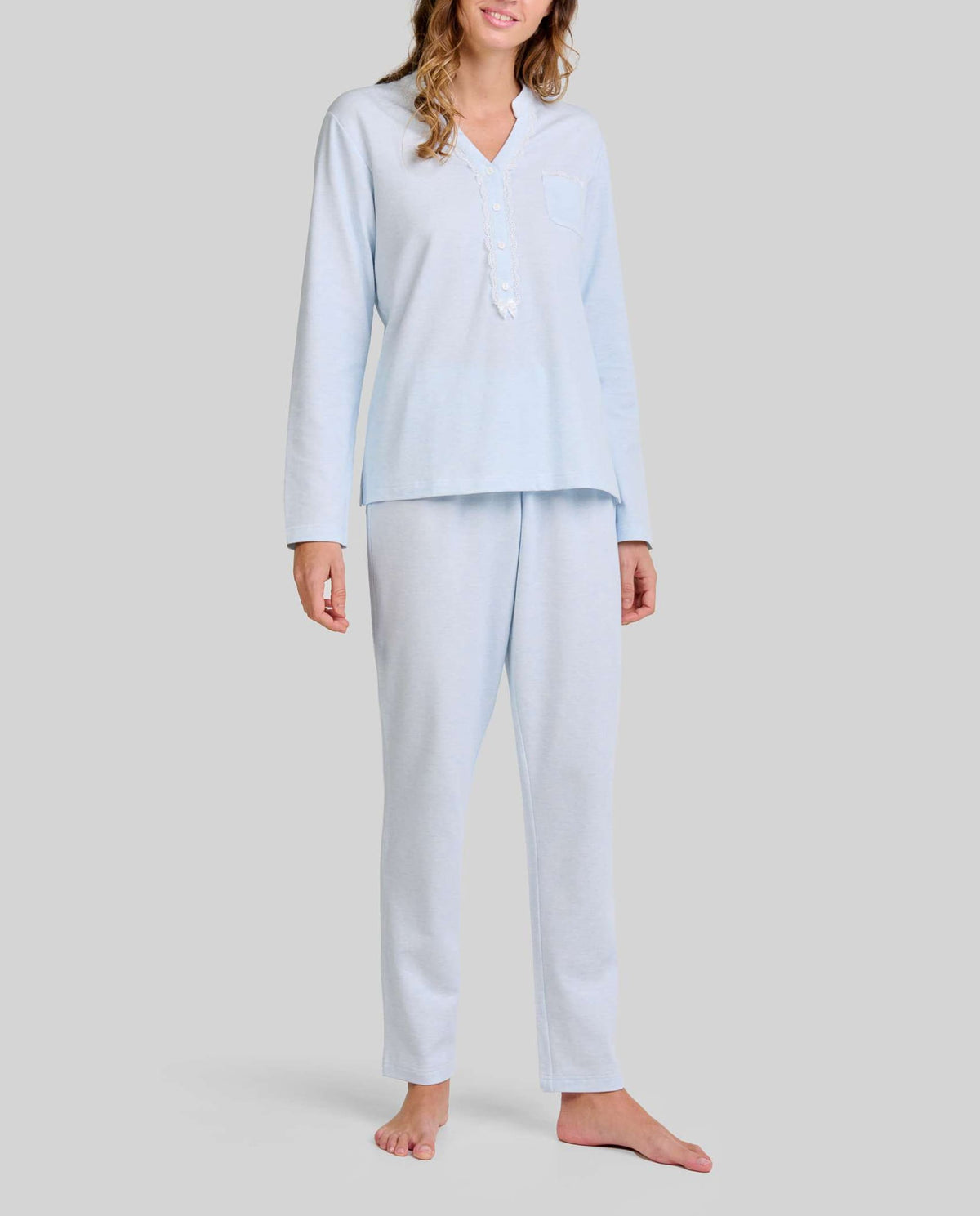 Mujer con pijama largo lencero color celeste de cuello abierto con puntilla y lazo