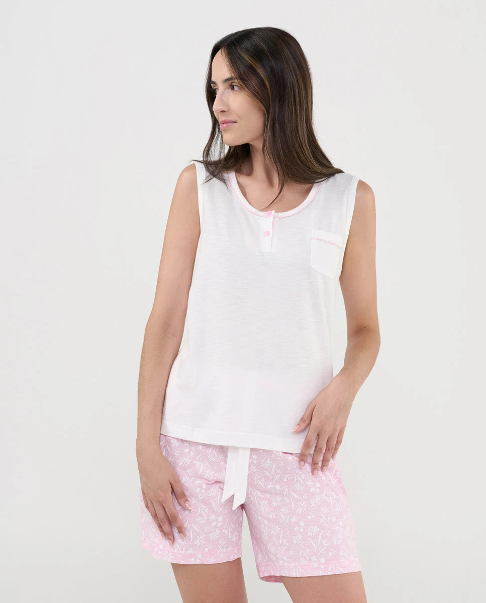 Mujer con pijama corto de verano sin mangas, camiseta blanca punto flamé y pantalón rosa con florecitas blancas
