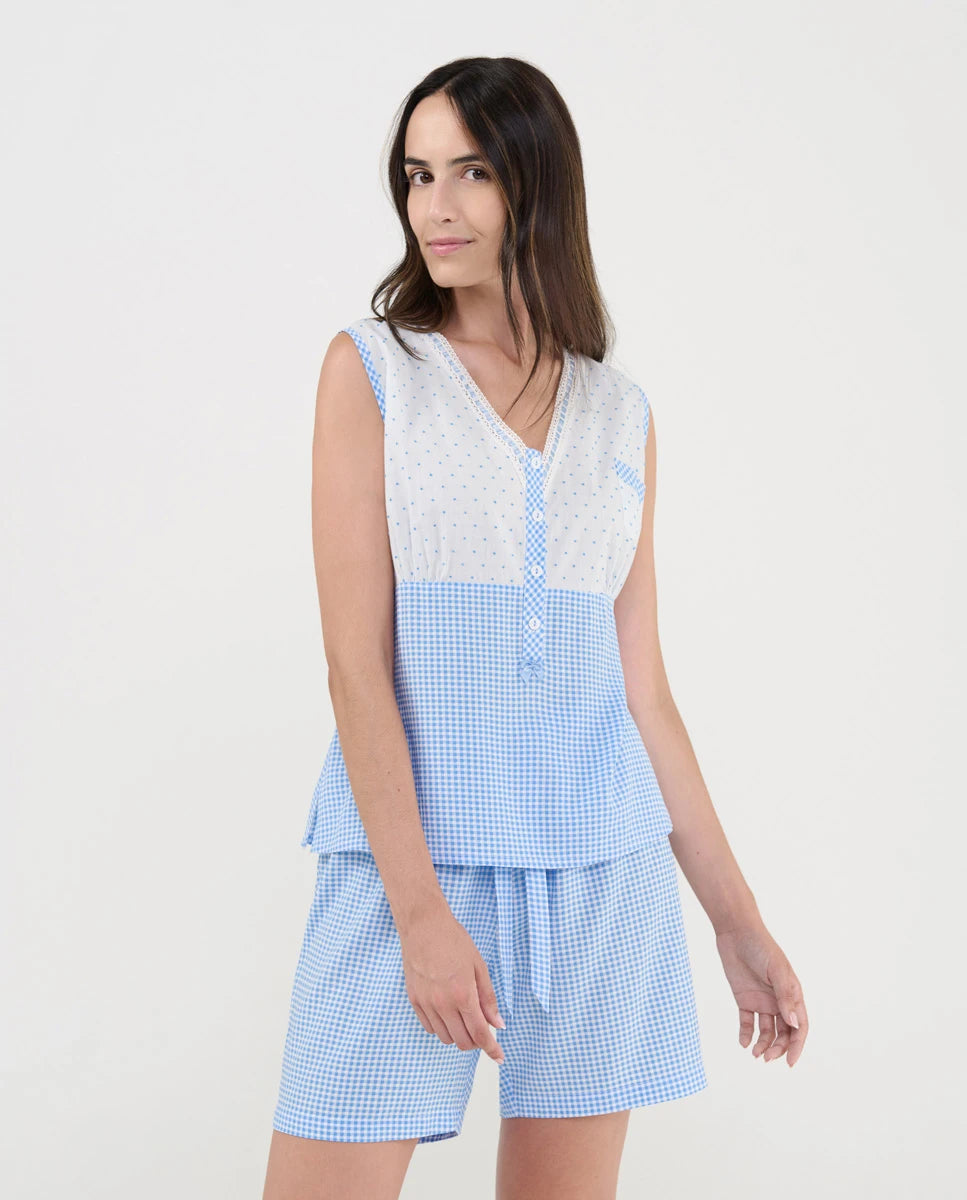 Mujer con pijama corto de verano, top sin mangas blanco plumeti y cuadritos celeste, pantalón ajustable cuadritos celeste.