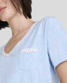 Detalle de camiseta de pijama de manga corta azul con detalles de florecillas en cuello pico y bolsillo