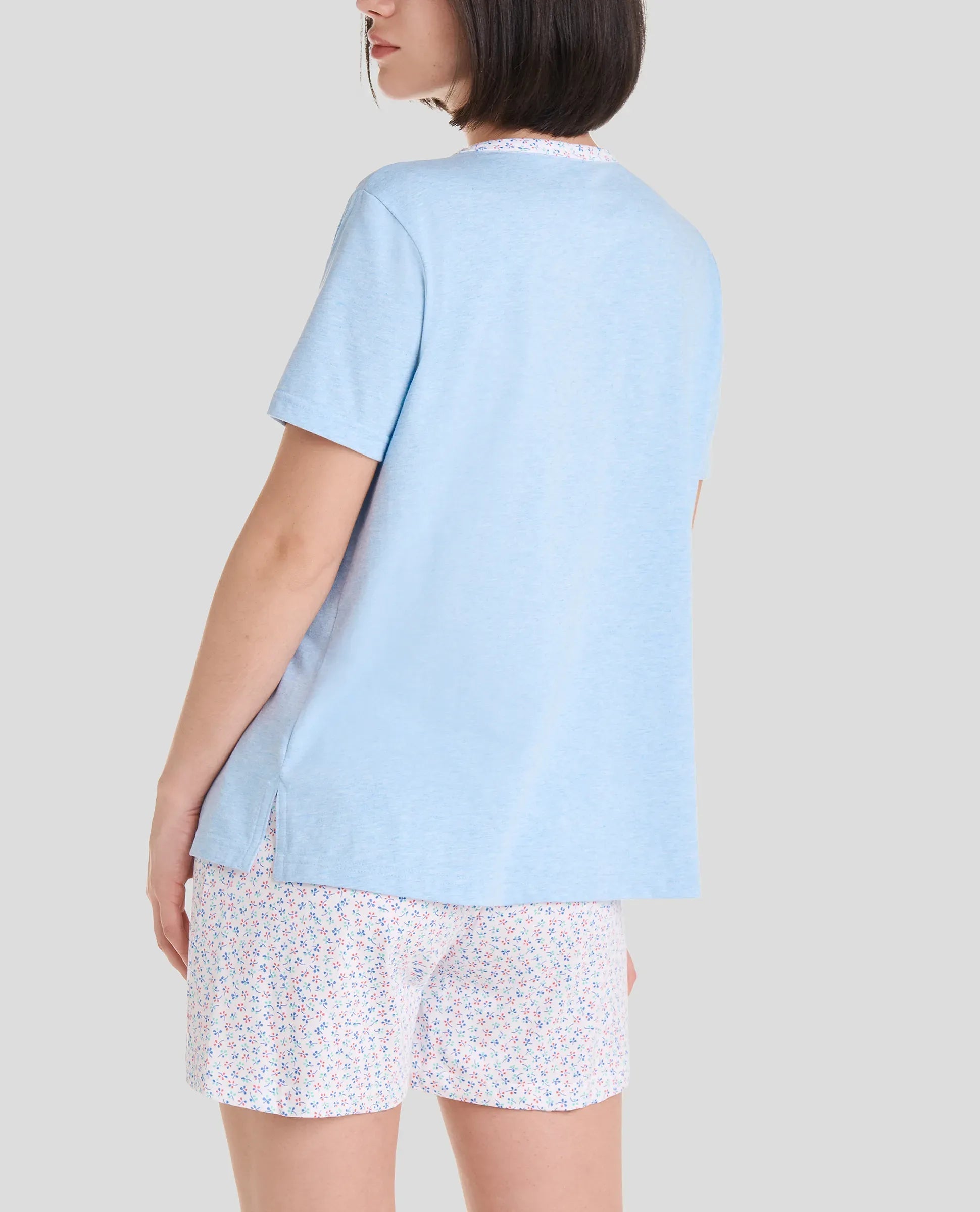 Mujer con pijama corto de manga corta, camiseta azul y pantalón corto de florecillas