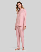 Mujer luce pijama de invierno abierto a rayas rosa palo de manga larga, con botones y bolsillo decorativo