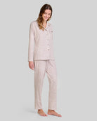 Mujer luce pijama camel de manga larga con estampado de florecitas, ideal para dormir cómoda.