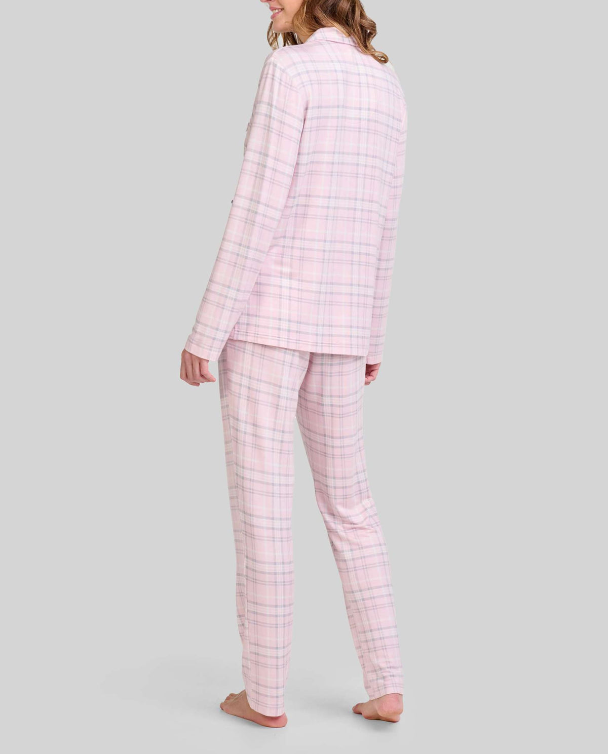 Mujer viste pijama rosa de cuadros con mangas largas y pantalón