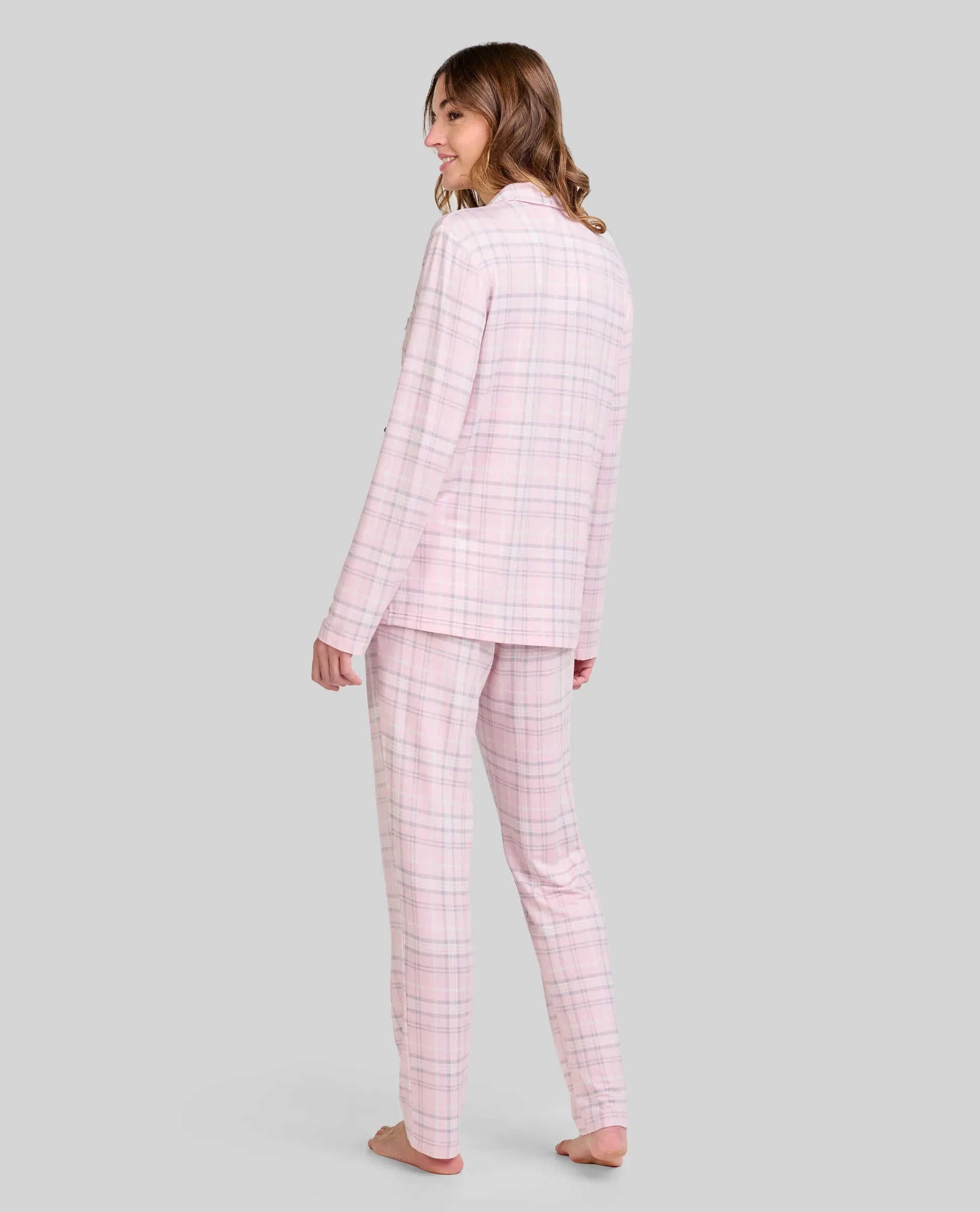 Mujer viste pijama rosa de cuadros con mangas largas y pantalón
