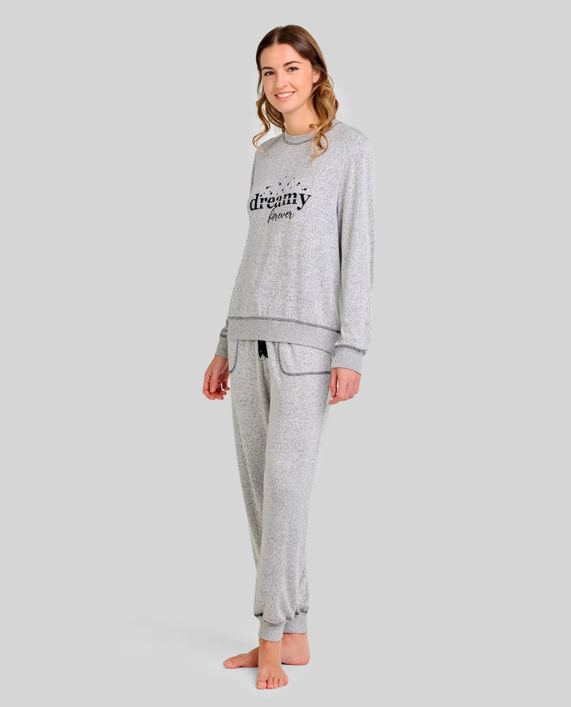 Mujer luce pijama vigoré gris de manga larga con bordado "dreamy" y puños elásticos