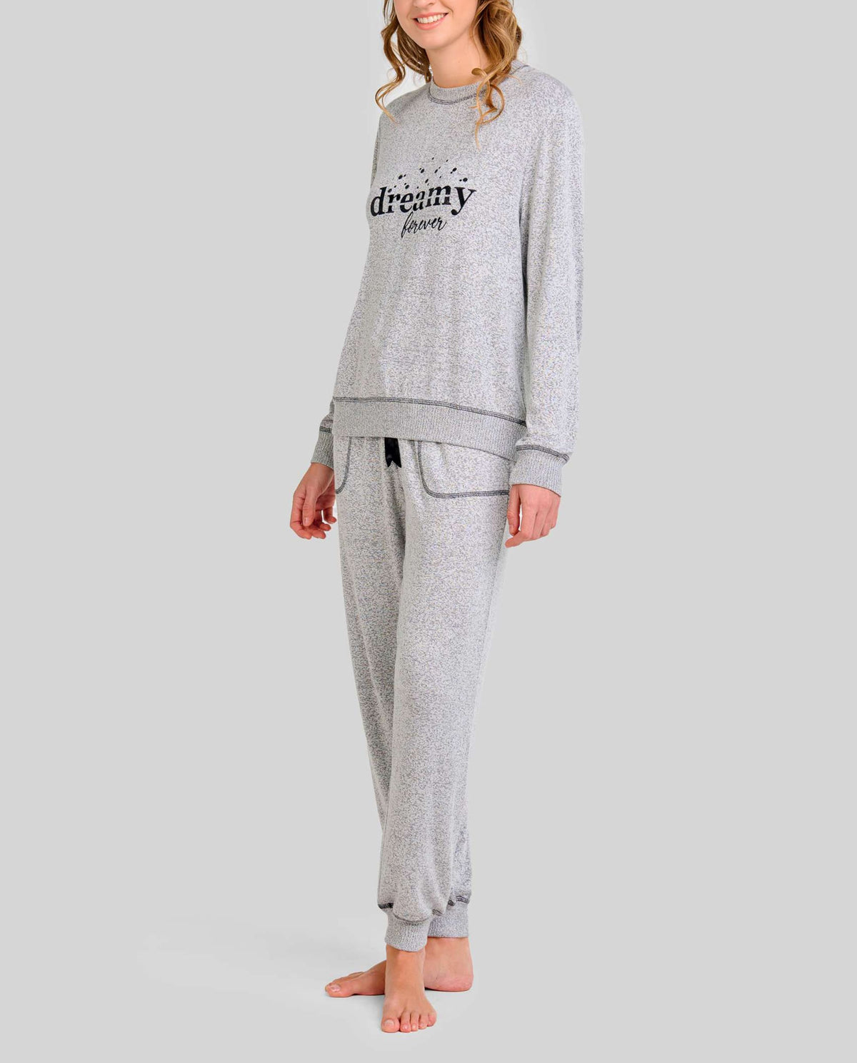 Mujer luce pijama vigoré gris de manga larga con bordado "dreamy" y puños elásticos