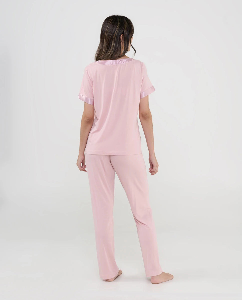 Mujer viste pijama de verano de manga corta en punto blanco y pantalón largo rosa con florecitas