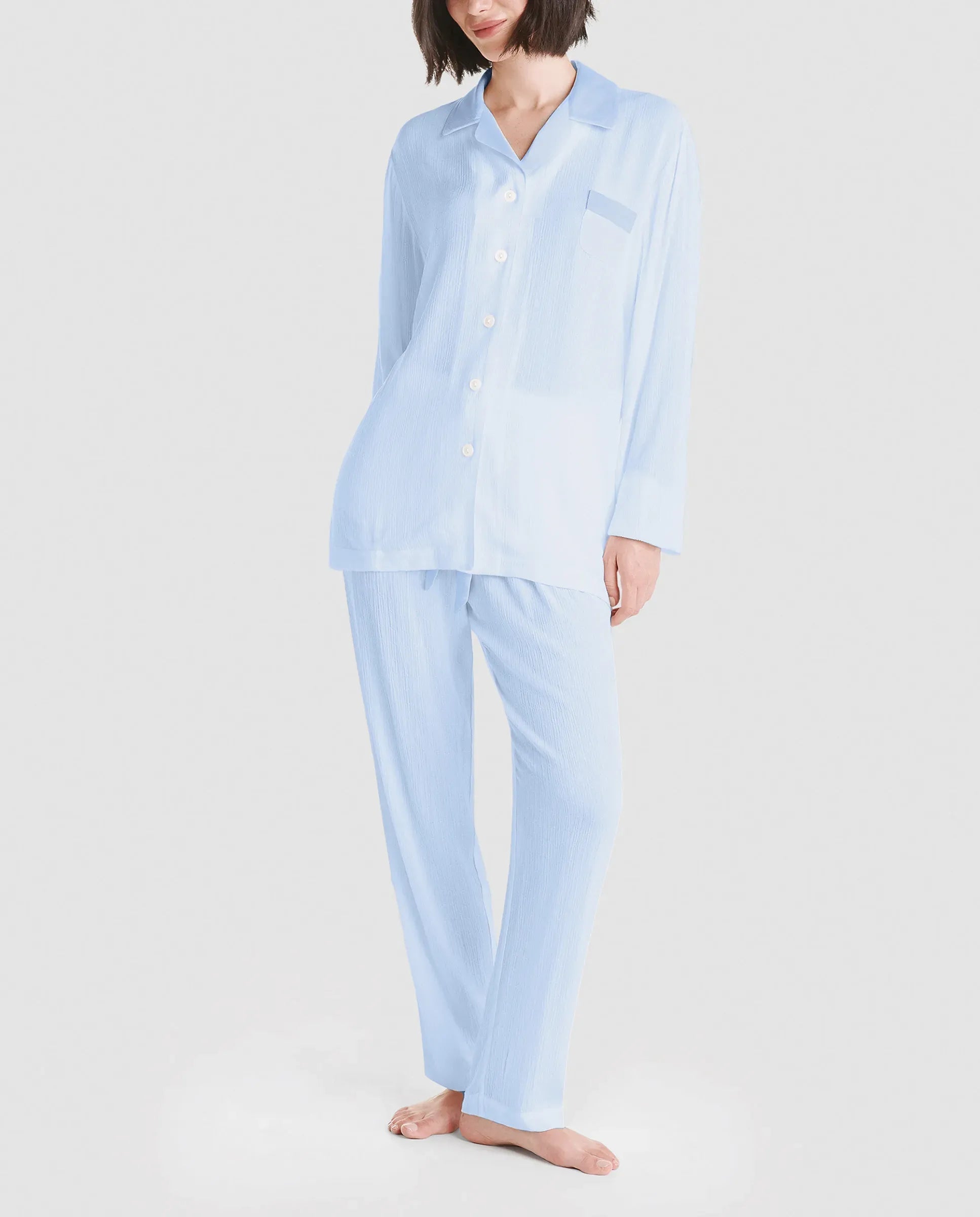 Modelo posa con pijama de verano gris con pantalón largo y camiseta manga corta estampado plumas