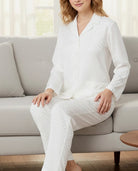 Mujer sentada en sofá con elegante pijama camisero jacquard marfil