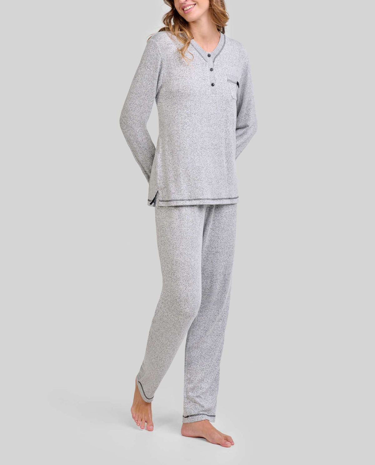 Mujer luciendo pijama gris de invierno de manga larga con cuello botones y bolsillo